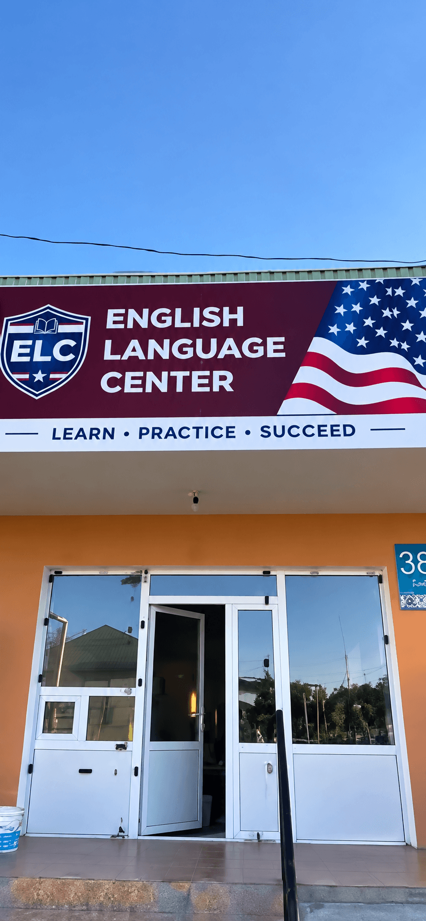 The English Language Center sign above the entrance, reading Learn, Practice, Succeed, with the doors open